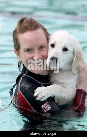 Cheltenham, Großbritannien. 10. Oktober 2020. Tracy Oliver umarmt ihren Welpen Brian, 16 Wochen alt. Hunde und ihre Besitzer haben die Möglichkeit, gemeinsam im Sandford Park Lido zu schwimmen, einem Freibad in Cheltenham, Gloucestershire, Großbritannien, am letzten Tag der Sommersaison, bevor der Pool für das Jahr geschlossen wird. Kredit: Thousand Word Media Ltd/Alamy Live Nachrichten Stockfoto