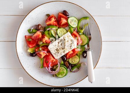 Traditioneller griechischer Salat mit Tomaten, grünen Paprika, Gurken, Kalamata-Oliven, Kapern, roten Zwiebeln und Feta-Käse Stockfoto