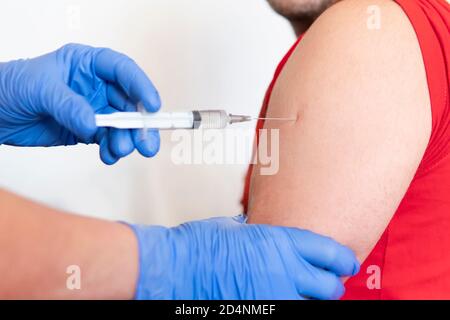 Nahaufnahme des Arztes, der die Impfung zum Patienten auf weißem Hintergrund macht, gesundes Konzept. Prävention der Ausbreitung von Coronavirus-Infektion covid 19 Stockfoto