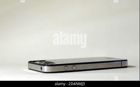 Gebrochene Handy auf einem weißen Hintergrund. Risse im Glas bei der Minianwendung Stockfoto