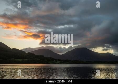 Atemberaubendes Landschaftsbild bei Sonnenaufgang mit Blick über Loweswater im See Bezirk in Richtung Low Fell und Grasmere mit bunten Himmel brechen Auf dem Berg Stockfoto