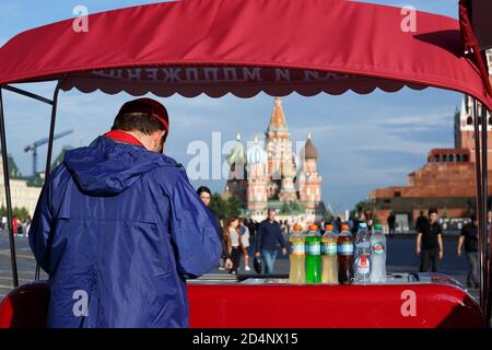 Moskau, Russland, 21. Juli 2020: Ein mobiler roter Kiosk mit Eis und Getränken befindet sich auf dem roten Platz mit Blick auf die Basilius-Kathedrale.