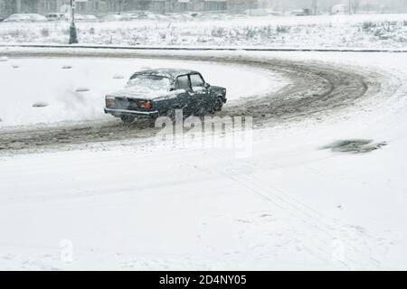 Auto driftet auf der Straße in der Stadt in einem Schwerer Schneesturm Stockfoto