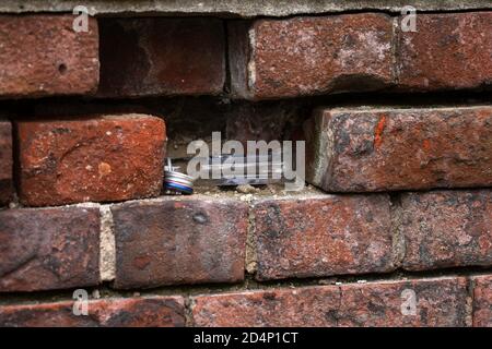 Leere Wodka-Flaschen versteckt in einem Bruch in alten mittelalterlichen Backsteinmauer. Gniezno, Polen. Stockfoto
