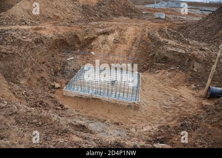 Verbindung eines Grabenabflusses mit einer Betonschachtkonstruktion auf der Baustelle. Betonstapel in Schalungsrahmen für Regenwasser und Unterholz zu konstruieren Stockfoto