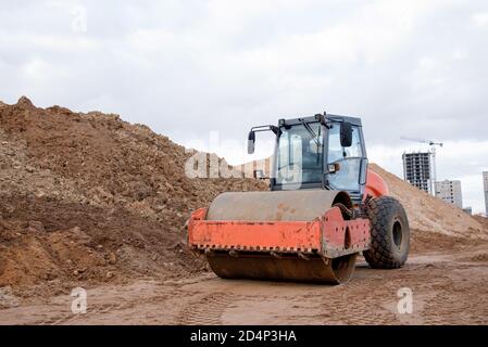 Bodenkompktor auf der Baustelle. Vibration Einzylinder-Straßenwalze zum Nivellieren von Boden, Kies, Beton oder Asphalt beim Straßenbau Stockfoto