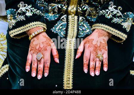 Die Hand der Braut ist mit Henna tätowiert. Ihre Hand ist voll von kostbarem Schmuck Stockfoto