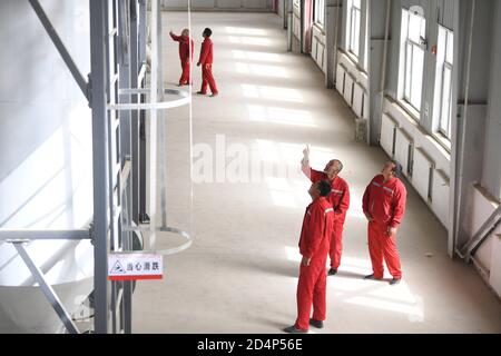 (201010) -- URUMQI, 10. Oktober 2020 (Xinhua) -- Dorfbewohner überprüfen die Ausrüstung einer Chili-Verarbeitungsfabrik in Tawakkul Township im Bezirk Hotan, nordwestlich von Xinjiang Uygur Autonome Region, 16. Mai 2020. Dank der Anstrengungen von allen Seiten sind in Xinjiang große Fortschritte erzielt worden. Von 2014 bis 2019 wurde eine solide wirtschaftliche Dynamik mit einer durchschnittlichen jährlichen BIP-Wachstumsrate von 7.2 Prozent aufrechterhalten. Der Lebensstandard der lokalen Bevölkerung hat sich mit einem durchschnittlichen jährlichen Wachstum von 9.1 Prozent des verfügbaren Pro-Kopf-Wohneinkommens und mehr als 2.92 Millionen davon deutlich verbessert Stockfoto