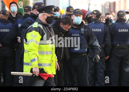 Mitglieder eines Garda entfernen während eines Anti-Lockdown-Protests vor dem Leinster House, Dublin, einen Gegendemonstrator, da Irland weiterhin landesweit an einer Stufe 3-Coronavirus-Sperre erkranst. Stockfoto