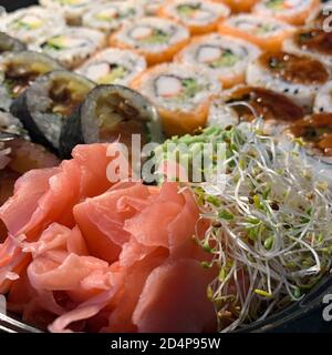 Japanisches Sushi-Essen. Verschiedene Maki, Brötchen, Nigiri, California Maki, mit Thunfisch, Lachs, Garnelen, Krabben und Avocado. Stockfoto