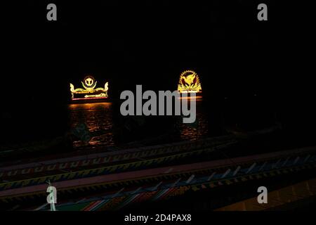 Lastkähne mit aufwendigen Werbedisplays schweben während des Bon um Touk Festivals entlang des mekong. Stockfoto