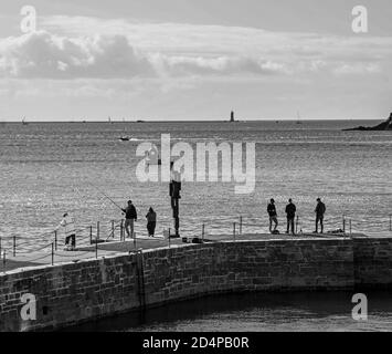 Monochrom Sir Anthony Gormleys ‘Look II’ 12ft Skulptur hat sich bereits in ihrem Zuhause am West Hoe Pier Plymouth niedergelassen. Eine menschliche Figur schaut auf das Seesym Stockfoto