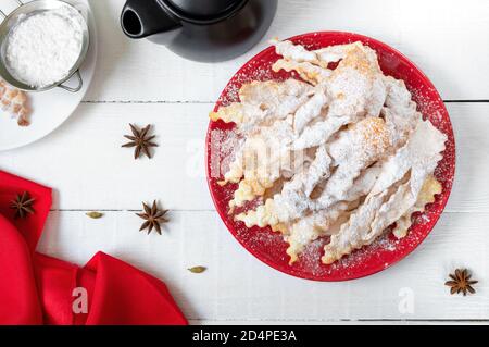 Reisig - knusprige frittierte Kekse in Puderzucker mit Tee und Marmelade. Ein traditioneller Leckerbissen auf europäischen Festivals. Stockfoto