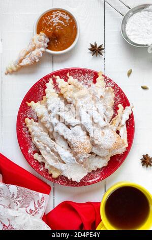 Reisig - knusprige frittierte Kekse in Puderzucker mit Tee und Marmelade. Ein traditioneller Leckerbissen auf europäischen Festivals. Stockfoto