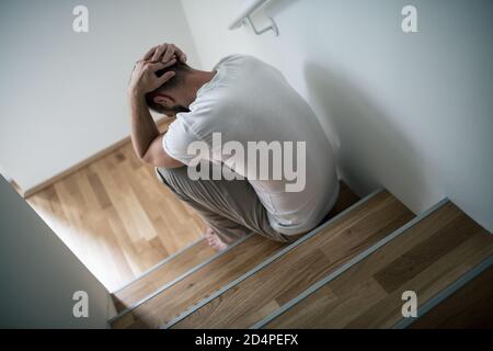 Deprimierter junger Mann zu Hause besorgt um Finanzen Stockfoto