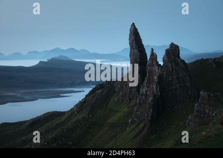 Atemberaubende Aussicht auf den großen Felsengipfel, der über einem See und dem Meer vor Sonnenaufgang thront. The Old man of Storr, Isle of Skye, Schottland, Großbritannien Stockfoto