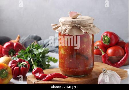 Gemüsesalat mit Auberginen, Karotten, Paprika, Zwiebeln und Tomaten im Glas auf Holzbrett, horizontales Format. Nahaufnahme Stockfoto