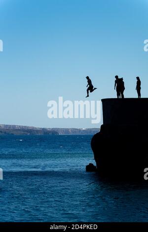 Gruppe von Freunden springen in mittelmeer von Felsen Klippe Stockfoto