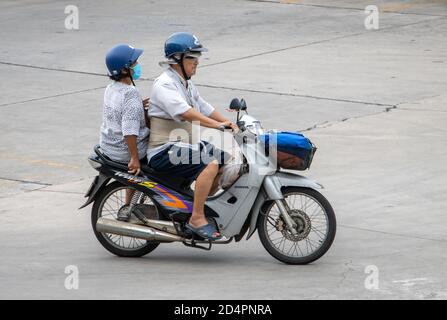 SAMUT PRAKAN, THAILAND, JULI 25 2020, EIN älteres Paar mit Helmen fährt auf dem Motorrad auf der Straße. Stockfoto