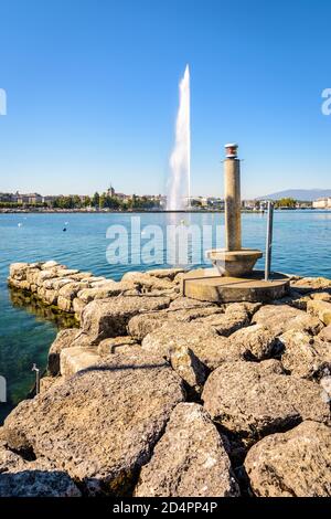 Die Stadt und die Bucht von Genf, Schweiz, mit der Kathedrale und dem symbolträchtigen 140 Meter hohen Wasserstrahlbrunnen auf dem Genfer See, aus einem Stein gesehen Stockfoto