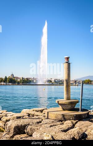 Die Stadt und die Bucht von Genf, Schweiz, mit der Kathedrale und dem symbolträchtigen 140 Meter hohen Wasserstrahlbrunnen auf dem Genfer See, aus einem Stein gesehen Stockfoto