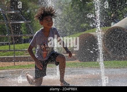Johannesburg, Südafrika. Oktober 2020. Ein Kind spielt um einen Brunnen in einem Park in Johannesburg, Südafrika, 10. Oktober 2020. Quelle: Chen Cheng/Xinhua/Alamy Live News Stockfoto