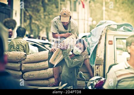 Ho Chi Minh, Vietnam. 07. August 2107: Vietnamesische Arbeiter sind mit dem Transport von Zementsäcken für den Bau in Ho Chi Minh City, Vietn, beschäftigt Stockfoto