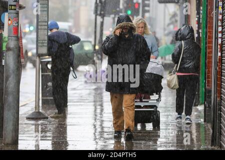 London, Großbritannien. Oktober 2020. An einem regnerischen Tag laufen die Menschen entlang der Straßen. Kredit: SOPA Images Limited/Alamy Live Nachrichten Stockfoto