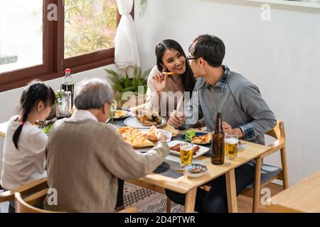 Glücklich asiatische multigenerational Familie von Papa Mama Tochter Mädchen und Großvater essen gemeinsam zu Hause. Glückliche Familie Engagement Zweisamkeit con Stockfoto