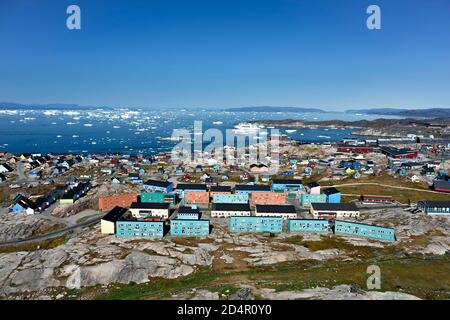 Stadtansicht mit bunten Häusern, Blick in die Disko Bay zum Kreuzfahrtschiff MS Deutschland, Ilulissat, Westgrönland, Grönland, Nordamerika Stockfoto