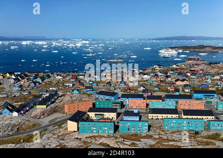 Stadtansicht mit bunten Häusern, Blick in die Disko Bay zum Kreuzfahrtschiff MS Deutschland, Ilulissat, Westgrönland, Grönland, Nordamerika Stockfoto