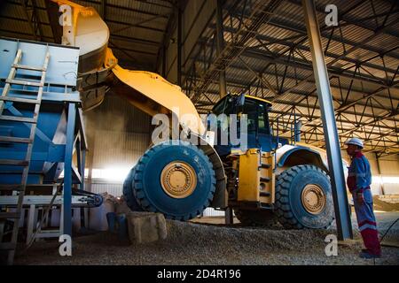 Region Aktobi/Kasachstan - Mai 04 2019: Phosphatdüngeanlage. Caterpillar Planierraupe oder Bagger Laden von Rohstoffen (Mineralien) in Maschine h Stockfoto