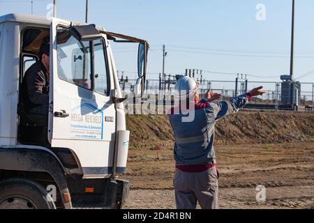 Region Aktobi/Kasachstan - Mai 04 2019: Phosphatdüngeanlage. Beladestation. Arbeiter zeigen Richtung für LKW-Fahrer. Stockfoto