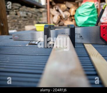 Geringe Schärfentiefe des Sägeschneidens durch Holzgeländer Auf der Terrasse Stockfoto