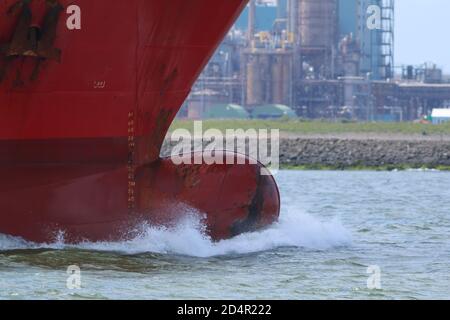 Knollenbogen eines Schiffes mit vor ihm brechender Welle Wie es die Industrie des europäischen Hafens passiert Stockfoto