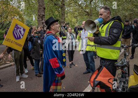 London, Großbritannien. Oktober 2020. Geza Tarjanyi (L) und Danny Shine (R) treten gegeneinander an. Anti-Covid19 Demonstranten marschieren unter starker Polizeipräsenz aus dem Hyde Park, um sich gegenüber der Downing Street als Teil der laufenden Demonstrationen gegen die aktuelle Regierung zu versammeln, die Coronavirus-Beschränkungen auferlegte. Die Verschwörungstheoretiker behaupten weiterhin, die Pandemie sei eine Falschmeldung und fordern keine weiteren Sperren, keine soziale Distanzierung, keine Masken, keine Spur und Spur, keine Gesundheitspässe, keine obligatorischen Impfungen und keine "neue Normalität". Kredit: Guy Corbishley/Alamy Live Nachrichten Stockfoto