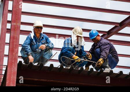 Shymkent, Kasachstan: Bau eines neuen Industriegebäudes des Chemiepharmazeutikereihauses Santo. Zwei Bauherren auf dem Dach machen Stahlverstärkung. Stockfoto