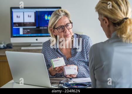 Arzt, der mit einem Patienten ein Schilddrüsen-Szintigramm bespricht. Levothyrox ® und Euthyrox ®, Behandlung von Hypothyreose. , Behandlung von Hypothyreose. Stockfoto