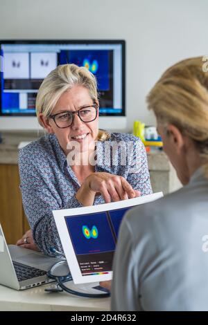 Arzt ein Szintigramm der Schilddrüse mit einer Patientin zu diskutieren. Stockfoto