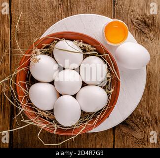 Weiße Hühnereier in Schüssel auf Holztisch. Draufsicht. Stockfoto