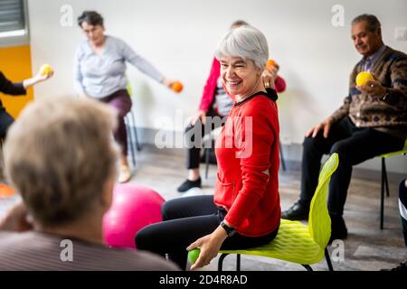 Körperliche Bewegung Programm durch einen Trainer erleichtert und überwacht von Eine Krankenschwester Asalée als Teil der Gesamtversorgung von Die älteren Untertan, um seine A zu erhalten Stockfoto