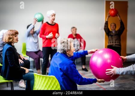 Körperliche Bewegung Programm durch einen Trainer erleichtert und überwacht von Eine Krankenschwester Asalée als Teil der Gesamtversorgung von Die älteren Untertan, um seine A zu erhalten Stockfoto