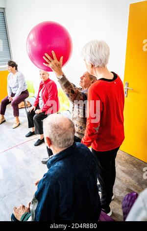 Körperliche Bewegung Programm durch einen Trainer erleichtert und überwacht von Eine Krankenschwester Asalée als Teil der Gesamtversorgung von Die älteren Untertan, um seine A zu erhalten Stockfoto