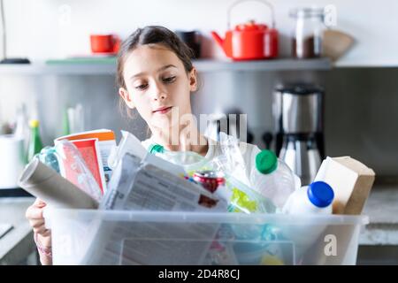 12-jähriges Mädchen, das recycelte Abfälle sortiert. Stockfoto