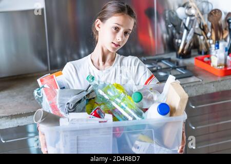 12-jähriges Mädchen, das recycelte Abfälle sortiert. Stockfoto