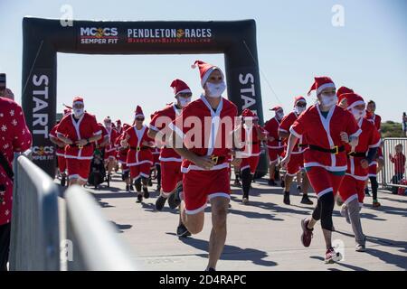 Servicemitglieder und ihre Familien sprinten während des Santa Run auf der Assault Craft Unit 5-Verbindung auf der Marine Corps Base Camp Pendleton, Kalifornien, 15. Dezember 2019 von der Startlinie. Der Santa Run ist Teil der "Hard Corps Race Series" der Marine Corps Community Services. MCCs sind ein umfassendes Programmangebot, das die Einsatzbereitschaft, die Kampffähigkeiten und die Lebensqualität der Marines, ihrer Familien, Rentner und Zivilisten unterstützt und verbessert. (USA Foto des Marine Corps von Lance Cpl. Andrew Cortez) Stockfoto