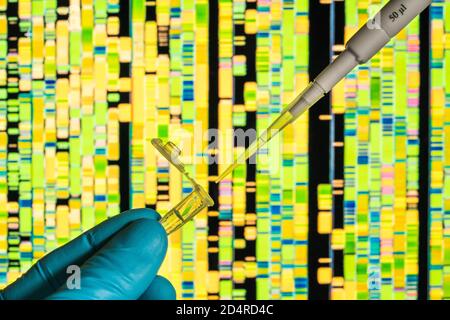 Genetische Forschung, Pipettieren in ein Reagenzglas vor einem DNA-Autoradiogramm (Deoxyribonukleinsäure). Stockfoto