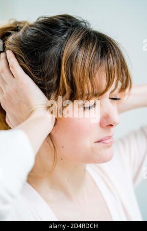 Frau hält ihre Hände an ihre schmerzhaften Ohren. Stockfoto