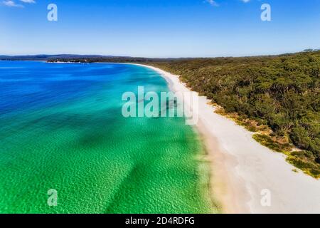 Smaragdwasser der Jervis Bucht im Sonnenlicht mit makellosem weißen Sandstrand und Dünen - Luftbild. Stockfoto