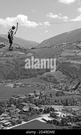 Tirol: Ein Mann balanciert im Zillertaler Hochseilgarten über die Skibretter. Ein Mann läuft über die Skier im Erlebnispark im Zillertal Stockfoto